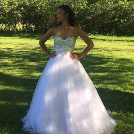 A pure white a line strapless gown with a sweetheart neckline. The bust of the gown is completely jeweled with silver jewels.