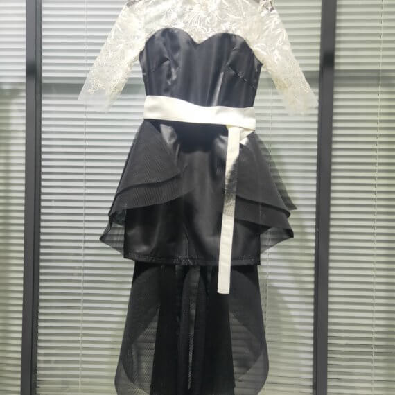 This 2 piece look begins with a black sweetheart neckline mini shift with contrasting white inset lace bodice, mandarin collar and elbow length sleeves. This mini is styled with a high low peplum two layer black tulle skirt tied at the waist with white satin bow.