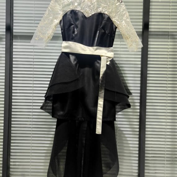 This 2 piece look begins with a black sweetheart neckline mini shift with contrasting white inset lace bodice, mandarin collar and elbow length sleeves. This mini is styled with a high low peplum two layer black tulle skirt tied at the waist with white satin bow.