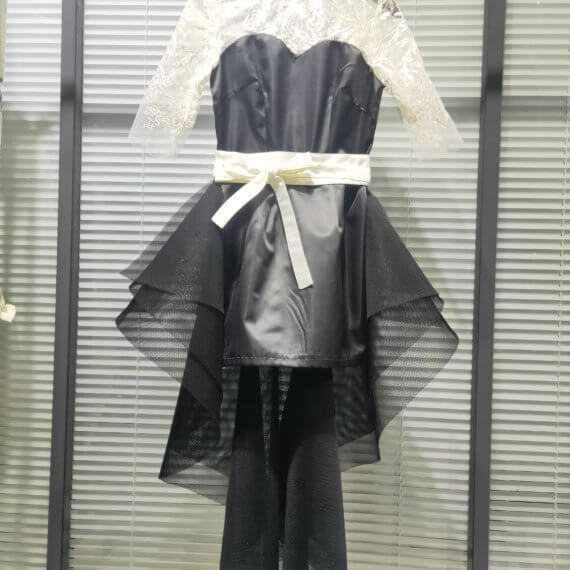 This 2 piece look begins with a black sweetheart neckline mini shift with contrasting white inset lace bodice, mandarin collar and elbow length sleeves. This mini is styled with a high low peplum two layer black tulle skirt tied at the waist with white satin bow.