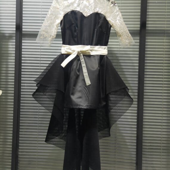 This 2 piece look begins with a black sweetheart neckline mini shift with contrasting white inset lace bodice, mandarin collar and elbow length sleeves. This mini is styled with a high low peplum two layer black tulle skirt tied at the waist with white satin bow.