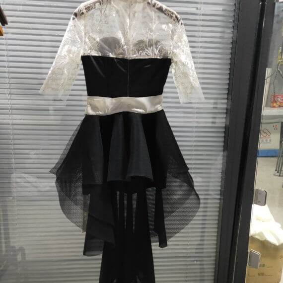 This 2 piece look begins with a black sweetheart neckline mini shift with contrasting white inset lace bodice, mandarin collar and elbow length sleeves. This mini is styled with a high low peplum two layer black tulle skirt tied at the waist with white satin bow.