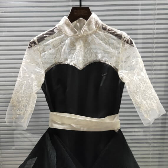 This 2 piece look begins with a black sweetheart neckline mini shift with contrasting white inset lace bodice, mandarin collar and elbow length sleeves. This mini is styled with a high low peplum two layer black tulle skirt tied at the waist with white satin bow.