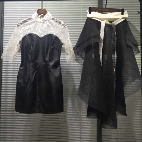 This 2 piece look begins with a black sweetheart neckline mini shift with contrasting white inset lace bodice, mandarin collar and elbow length sleeves. This mini is styled with a high low peplum two layer black tulle skirt tied at the waist with white satin bow.